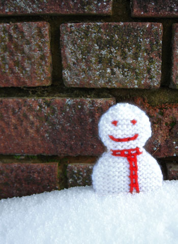 photo of two tone snowman decoration in the snow