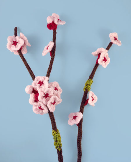 photo of knitted blossom twig on blue